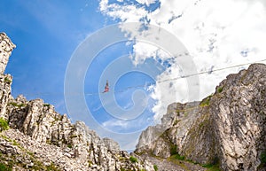 Young slackliner man balancing on a slackline betweend two rocks. Highline with a beautiful natural landscape behind photo