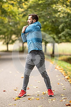 A young athlete is warming up before running training in the park