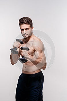 Young athlete on a white background lifts dumbbells. training a bearded man athletic build