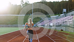Young Athlete Woman Running Fast at Track in the Morning Light , Training Hard, Getting Ready for Race Competition or