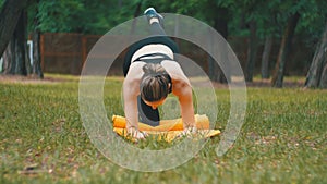 Young Athlete Woman in Sport Outfit Engaged Fitness Lying on a Carpet in a Park on a Green Lawn
