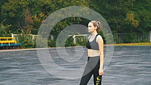 Young athlete woman in sport outfit engaged in fitness on the sports field in the park.