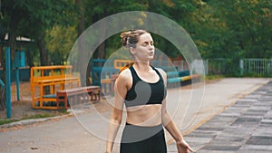 Young athlete woman in sport outfit engaged in fitness on the sports field in the park.