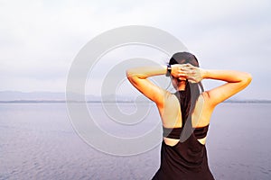 Young athlete woman streching near the lake outdoor, asian Fitness walking and exercise in sunset scene. wellness and sport