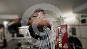 Young athletic african man fighting on ring at gym while preparing for battle with opponent