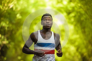 Young athletic and attractive black afro American runner man doing running workout training outdoors on urban city park in fitness