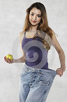 Young athletic female silhouette, apple and old big pants
