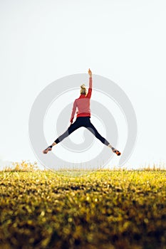 Young athletic girl in a jump with hand raised up. The concept of sport, healthy lifestyle and successfull
