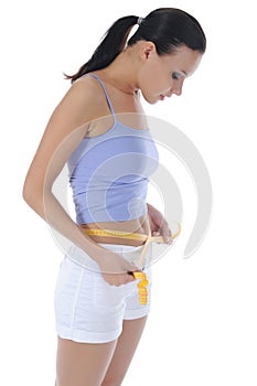 Young athletic girl measuring waist.