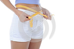 Young athletic girl measuring waist.