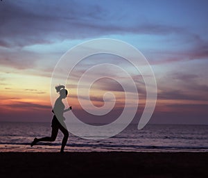 Young, athletic lady jogging on a beach during the susnet