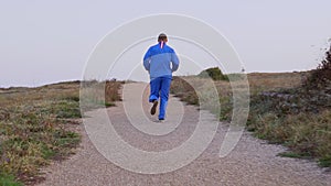 Young athletic man doing gymnastics on the sea early in the morning