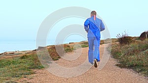 Young athletic man doing gymnastics on the sea early in the morning