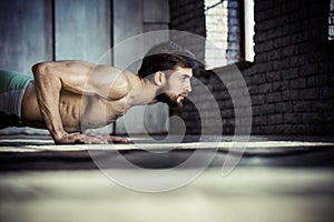 Young athletic man doing push-ups.