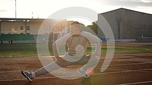 Young athletic man doing warm-up before exercise and jogging