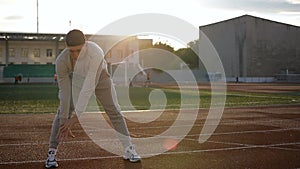 Young athletic man doing warm-up before exercise and jogging