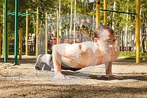 Young Athletic Man Exercising Outdoors Push-ups. Healthy lifestyle concept.