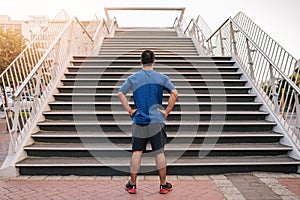 Young athletic man preparing to run up steep stairs