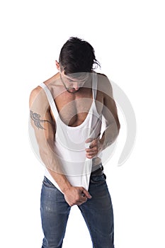 Young athletic man pulling down tanktop