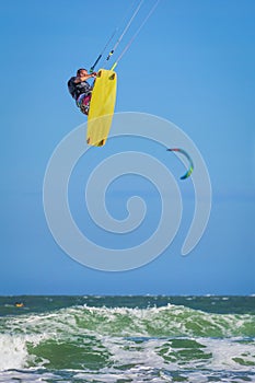 Young athletic man riding kite surf on a sea