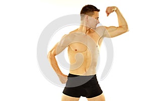 Young athletic man shows biceps