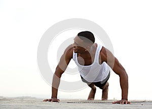 Young athletic man smiling and doing push ups
