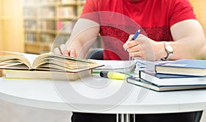 Young athletic man and student studying and writing notes.