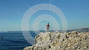 Young athletic man walking on rock