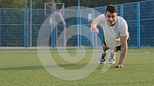 Young athletic Middle Eastern Indian sportsman runner or footballer in summer sportswear doing warm-up before training