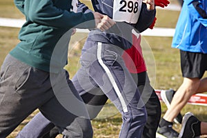 Young athletic runners on a cross country race. Outdoor circuit.