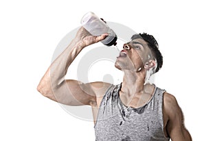 Young athletic sport man thirsty drinking water holding bottle pouring fluid on sweaty face