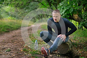 Young athletic sportmanr in a black shirt, leggings and sneake