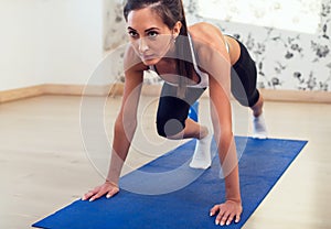 Young athletic sporty slim woman doing exercises