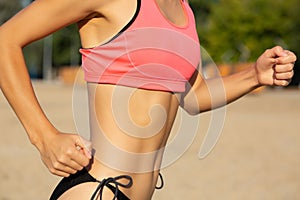 Young athletic woman doing cardio workout at the beach