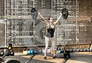 Young athletic woman doing the snatch in a gym