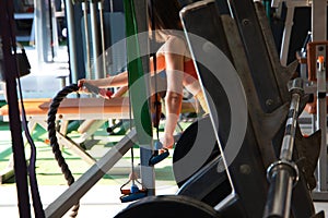 Young athletic woman doing some crossfit exercises with some battle ropes in the gym. gymnastics, sport, rope, training, athlete,