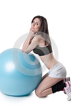 Young athletic woman exercised with a blue stability ball