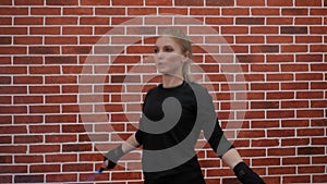 A young athletic woman jumps on a rope in a sports boxing gym.