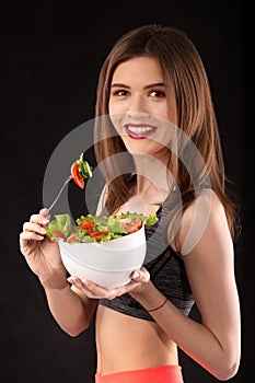 Young athletic woman with a salad