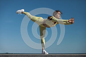 young athletic woman in yellow tracksuit by the sea