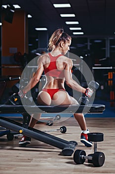 young athletics girl with perfect slim fit with dumbbells in gym