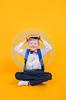 Young atractive boy wearing school unifor while holding his school books on heard