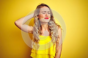 Young attactive woman wearing t-shirt standing over yellow isolated background confuse and wonder about question