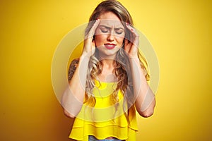 Young attactive woman wearing t-shirt standing over yellow isolated background with hand on head for pain in head because stress