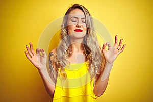 Young attactive woman wearing t-shirt standing over yellow isolated background relax and smiling with eyes closed doing meditation