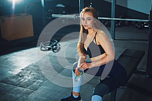 Young attracrive sport woman sitting with water bottle