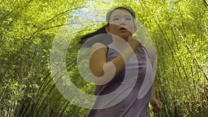 Young attractive and active Asian Chinese woman with pony tail running practicing jogging workout at beautiful city park in