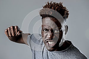 Young attractive african american black man in rage threaten punching with fist in angry upset