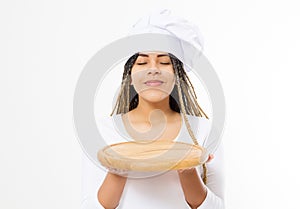 Young attractive african american woman in cooking hat holding empty wood pizza cutting board isolated on white background. Copy
