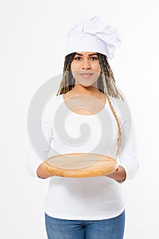 Young attractive african american woman in cooking hat holding empty wood pizza cutting board isolated on white background. Copy